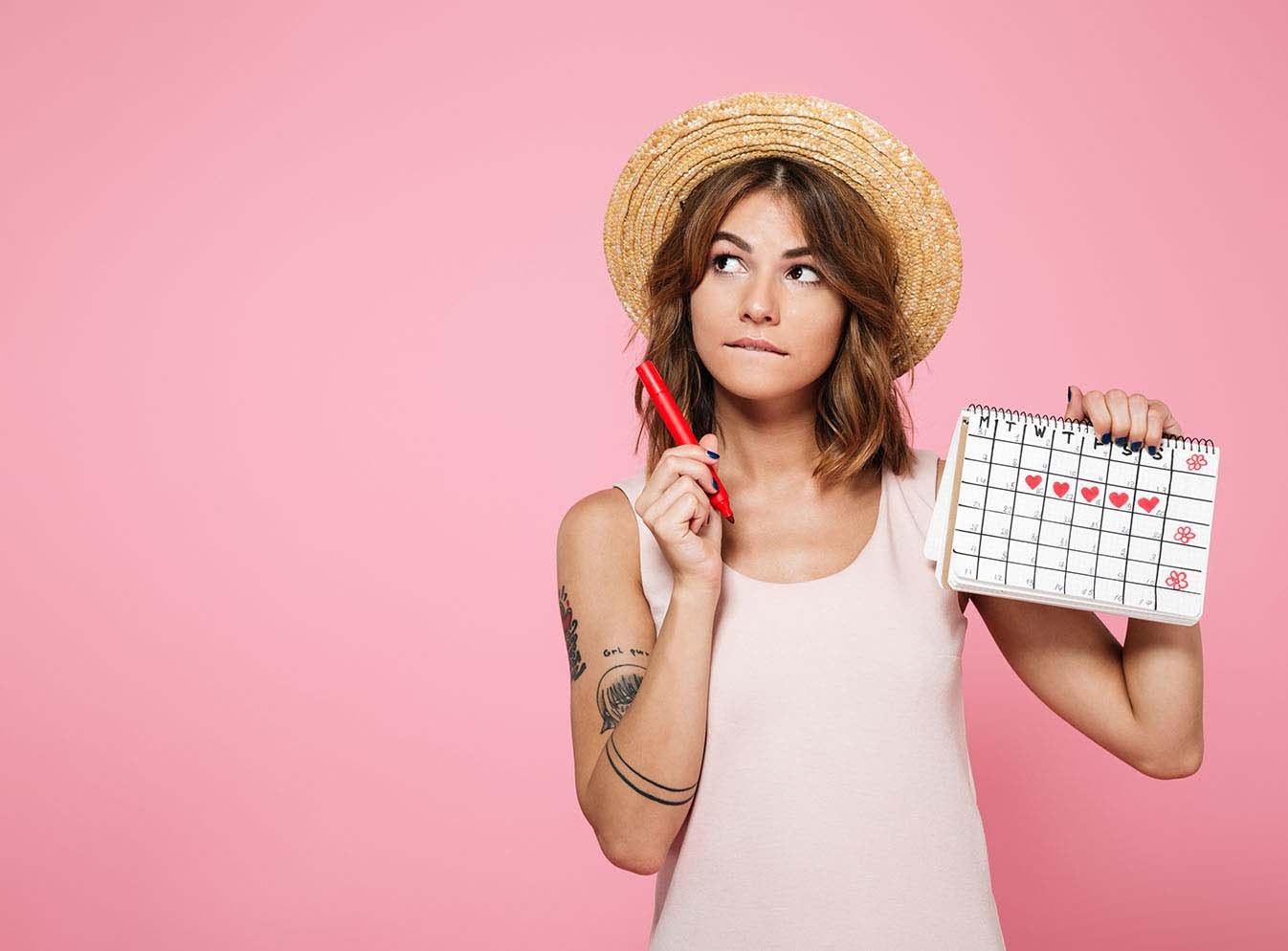 Woman holding up calendar that tracks her menstrual cycle