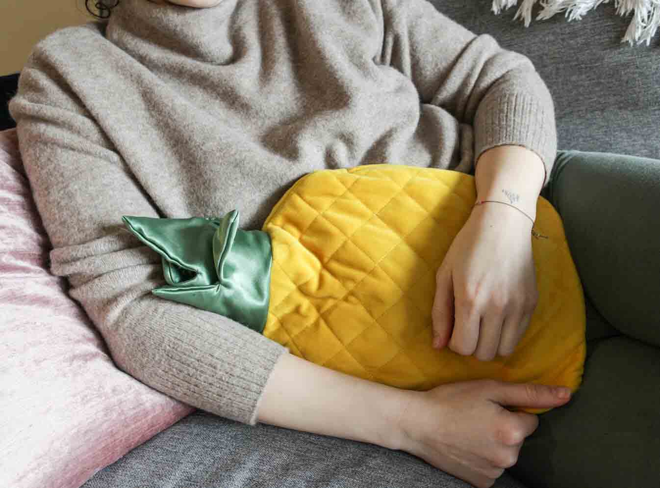 Person holding heating pads against abdomen to relieve cramps